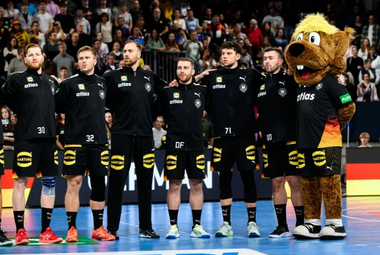 Männer-Nationalmannschaft Handball bei der Hymne mit Maskottchen.